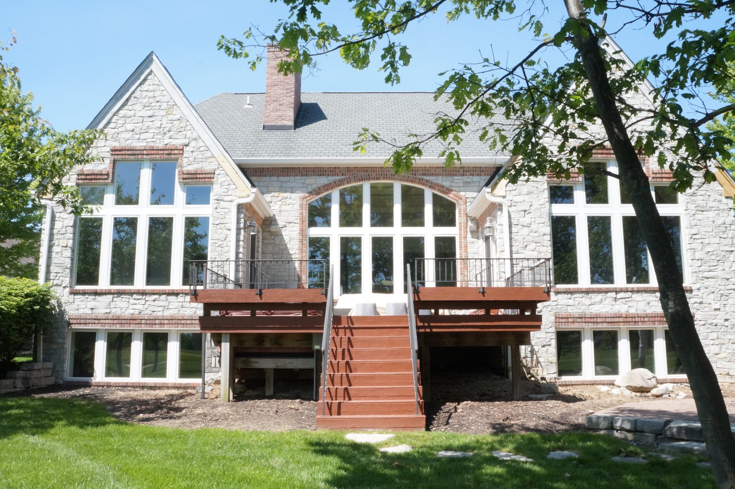 White Marvin Essential replacement windows across the rear of a Carmel home, with tall window groupings overlooking the deck.